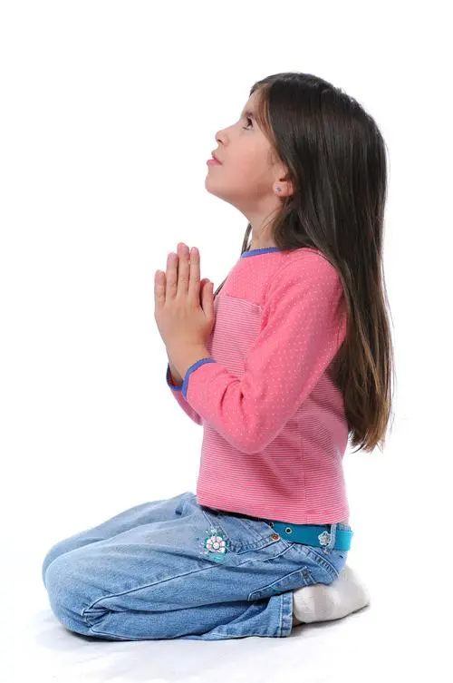 小孩跪在地上双手合十祈祷她跪下祈祷的女孩